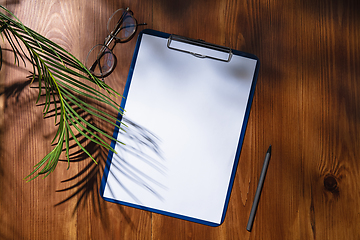 Image showing Creative and cozy workplace at home office, inspirational mock up with plant shadows on table surface