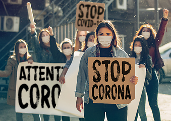 Image showing Young people in face masks protesting of stop coronavirus pandemic on the street