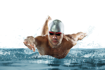 Image showing Professional male swimmer with hat and goggles in motion and action, healthy lifestyle and movement concept