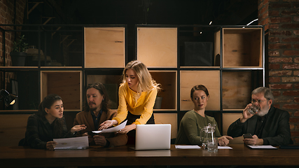 Image showing Young colleagues working together in a office styled like classical artworks. Look busy, attented, cheerful, successful. Concept of business, office, finance.