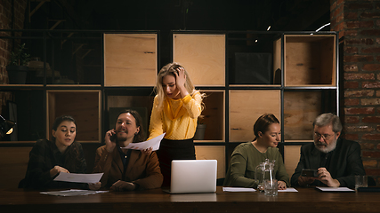 Image showing Young colleagues working together in a office styled like classical artworks. Look busy, attented, cheerful, successful. Concept of business, office, finance.