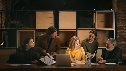 Image showing Young colleagues working together in a office styled like classical artworks. Look busy, attented, cheerful, successful. Concept of business, office, finance.