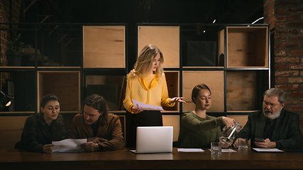 Image showing Young colleagues working together in a office styled like classical artworks. Look busy, attented, cheerful, successful. Concept of business, office, finance.