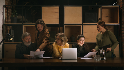 Image showing Young colleagues working together in a office styled like classical artworks. Look busy, attented, cheerful, successful. Concept of business, office, finance.