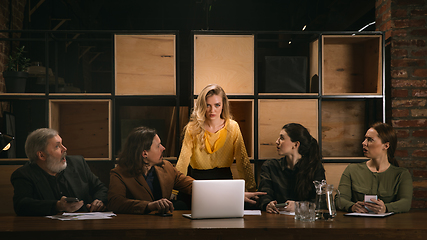 Image showing Young colleagues working together in a office styled like classical artworks. Look busy, attented, cheerful, successful. Concept of business, office, finance.