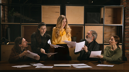 Image showing Young colleagues working together in a office styled like classical artworks. Look busy, attented, cheerful, successful. Concept of business, office, finance.