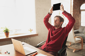 Image showing Caucasian entrepreneur, businessman, manager trying to work, looks funny, lazy and spending time