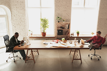 Image showing Caucasian entrepreneur, businessman, manager trying to work, looks funny, lazy and spending time