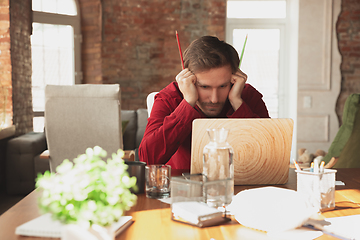 Image showing Caucasian entrepreneur, businessman, manager trying to work, looks funny, lazy and spending time