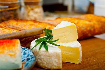 Image showing French cheese and fresh  baguette on a wood cutter