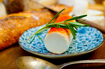 Image showing French cheese and fresh  baguette on a wood cutter