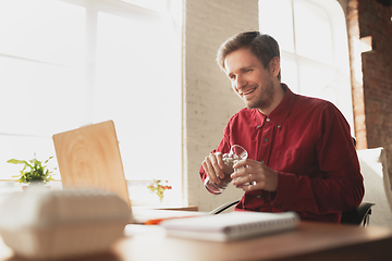 Image showing Caucasian entrepreneur, businessman, manager trying to work, looks funny, lazy and spending time