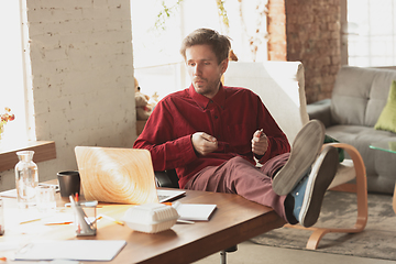 Image showing Caucasian entrepreneur, businessman, manager trying to work, looks funny, lazy and spending time