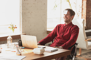 Image showing Caucasian entrepreneur, businessman, manager trying to work, looks funny, lazy and spending time