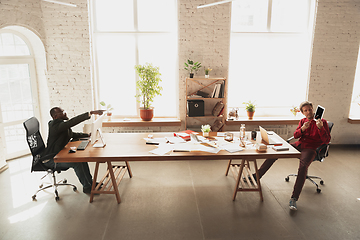 Image showing Caucasian entrepreneur, businessman, manager trying to work, looks funny, lazy and spending time