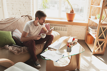 Image showing Young man studying at home during online courses for financist, economist, managers