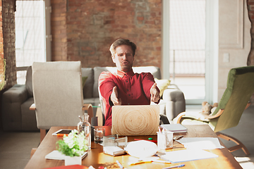 Image showing Caucasian entrepreneur, businessman, manager trying to work, looks funny, lazy and spending time