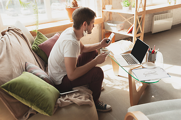 Image showing Young man studying at home during online courses for designers, SMM, SEO, analytics