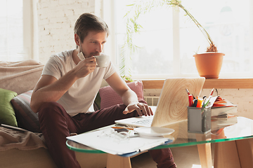 Image showing Young man studying at home during online courses for financist, economist, managers