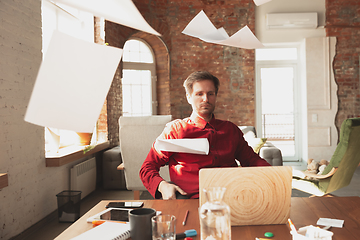 Image showing Caucasian entrepreneur, businessman, manager trying to work, looks funny, lazy and spending time