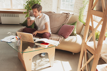 Image showing Young man studying at home during online courses for financist, economist, managers