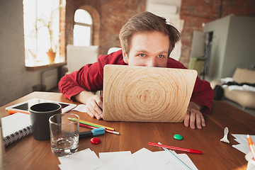 Image showing Caucasian entrepreneur, businessman, manager trying to work, looks funny, lazy and spending time