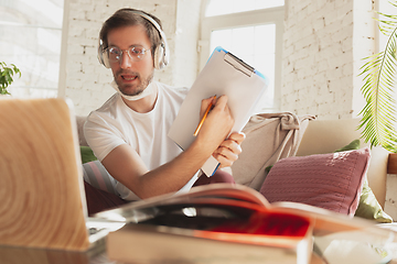 Image showing Young man studying at home during online courses for laborer, journalist, developer.