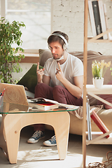 Image showing Young man studying at home during online courses for programmer, bug-tester, consulter