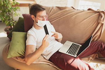 Image showing Young man studying at home during online courses for disinfector, nurse, medical services