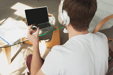 Image showing Young man studying at home during online courses for photographer, studio assistant