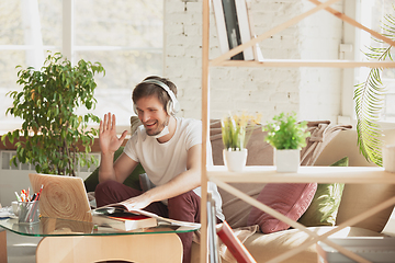 Image showing Young man studying at home during online courses for marketer, architect, translator