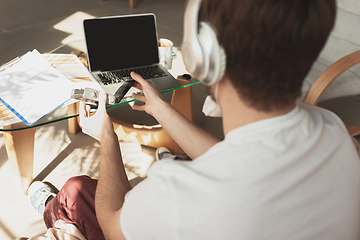 Image showing Young man studying at home during online courses for photographer, studio assistant