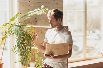 Image showing Young man studying at home during online courses for gardener, biologist, florist