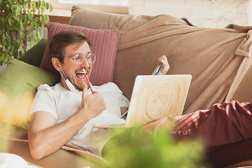 Image showing Young man studying at home during online courses for journalist, critics, writers