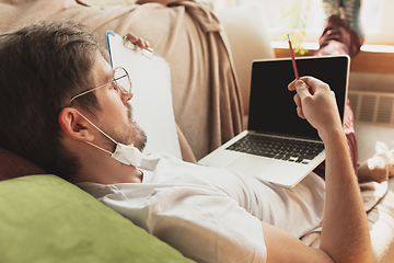 Image showing Young man studying at home during online courses for journalist, critics, writers