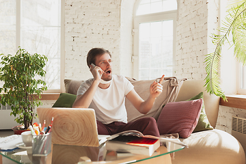 Image showing Young man studying at home during online courses for designers, SMM, SEO, analytics