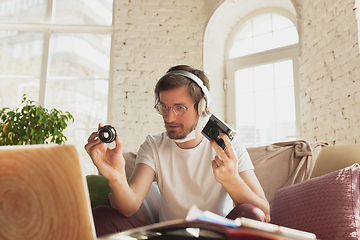 Image showing Young man studying at home during online courses for photographer, studio assistant