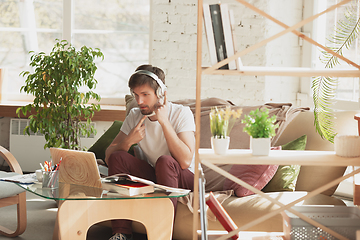 Image showing Young man studying at home during online courses for marketer, architect, translator