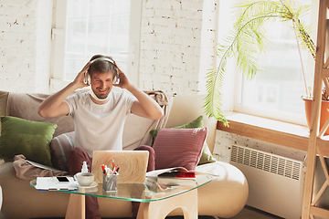 Image showing Young man studying at home during online courses for marketer, architect, translator