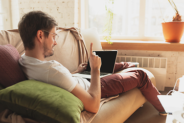 Image showing Young man studying at home during online courses for journalist, critics, writers