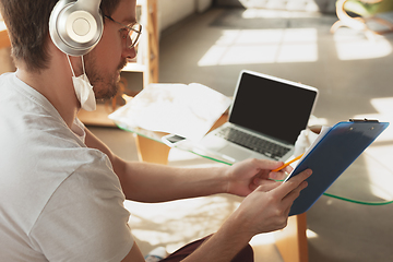 Image showing Young man studying at home during online courses for laborer, journalist, developer.