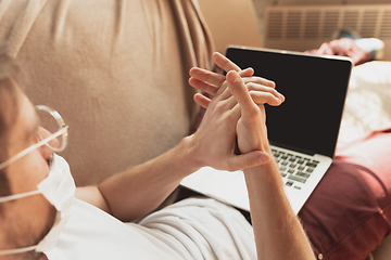 Image showing Young man studying at home during online courses for disinfector, nurse, medical services