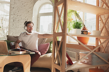 Image showing Young man studying at home during online courses for laborer, journalist, developer.