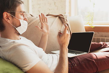 Image showing Young man studying at home during online courses for disinfector, nurse, medical services