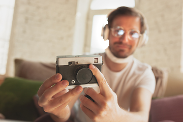 Image showing Young man studying at home during online courses for photographer, studio assistant