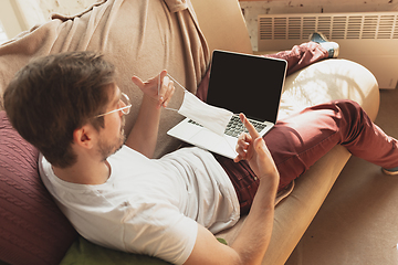 Image showing Young man studying at home during online courses for disinfector, nurse, medical services