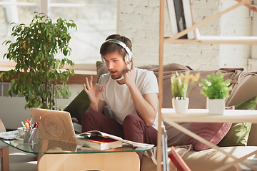 Image showing Young man studying at home during online courses for programmer, bug-tester, consulter