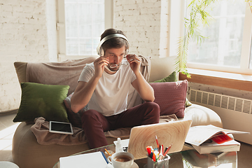 Image showing Young man studying at home during online courses for programmer, bug-tester, consulter