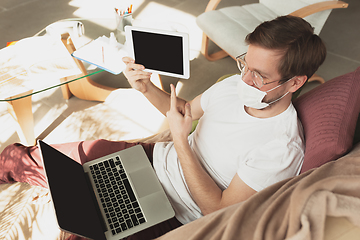 Image showing Young man studying at home during online courses for disinfector, nurse, medical services