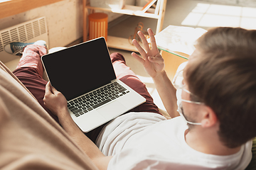 Image showing Young man studying at home during online courses for disinfector, nurse, medical services